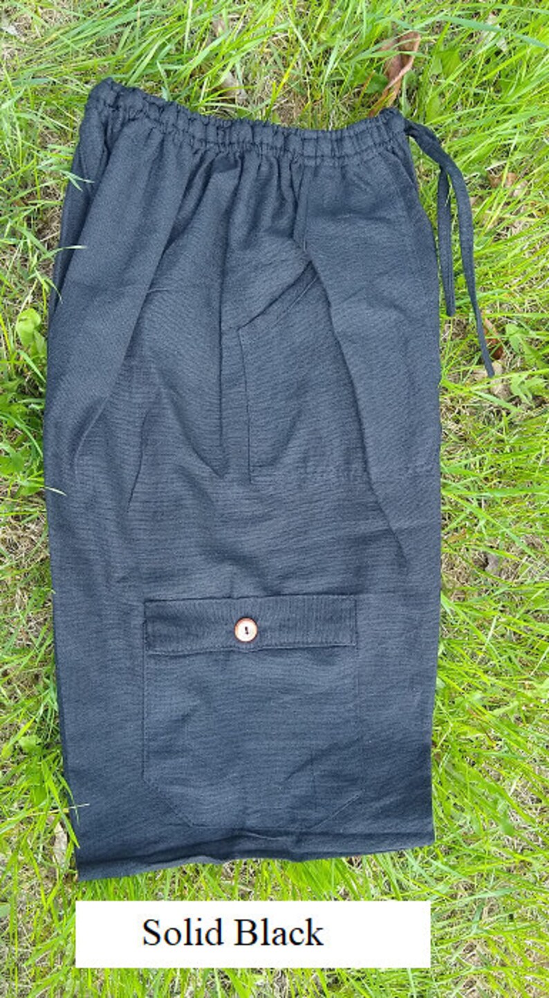 May include: Black cotton shorts with a single button pocket and drawstring waist.