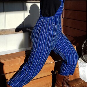 Puede incluir: Pantal&oacute;n vaquero azul y blanco a rayas con botas de cuero marr&oacute;n. El pantal&oacute;n tiene una pierna ancha y est&aacute; hecho de una tela suave y c&oacute;moda.