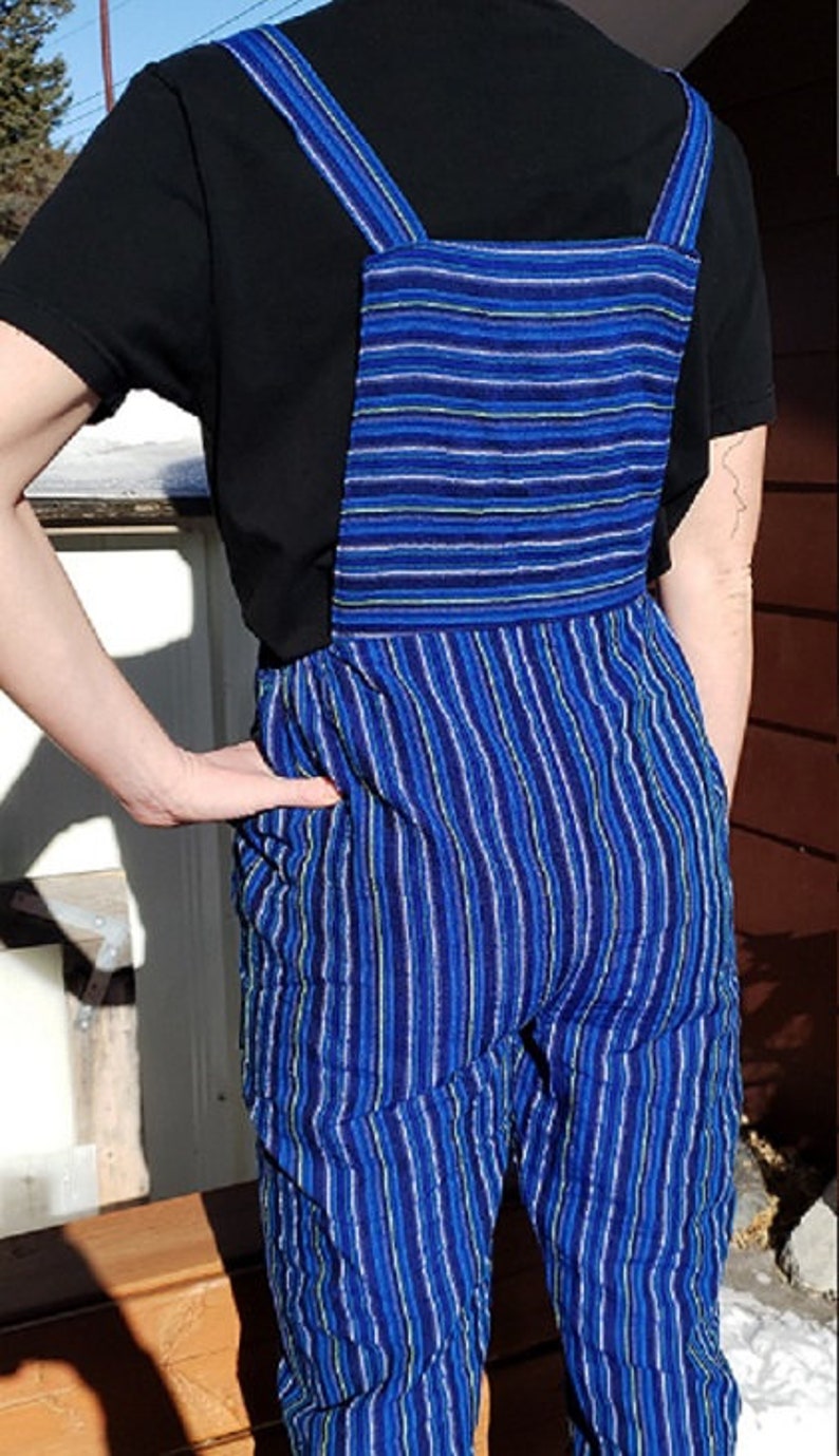 Puede incluir: Pantal&oacute;n vaquero azul y blanco a rayas con una camiseta negra debajo.