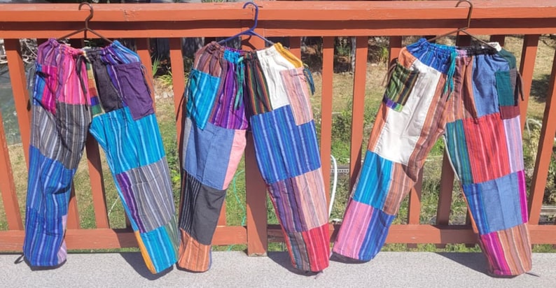 May include: Three pairs of colorful patchwork pants with a drawstring waist. The pants are made of different fabrics and colors, including blue, red, green, purple, and white.