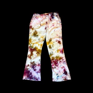May include: A pair of tie-dye flared pants with a white, yellow, brown, and pink color scheme.