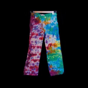 May include: Tie-dye pants with a rainbow color pattern. The pants have a button fly and are made of a soft, comfortable fabric.