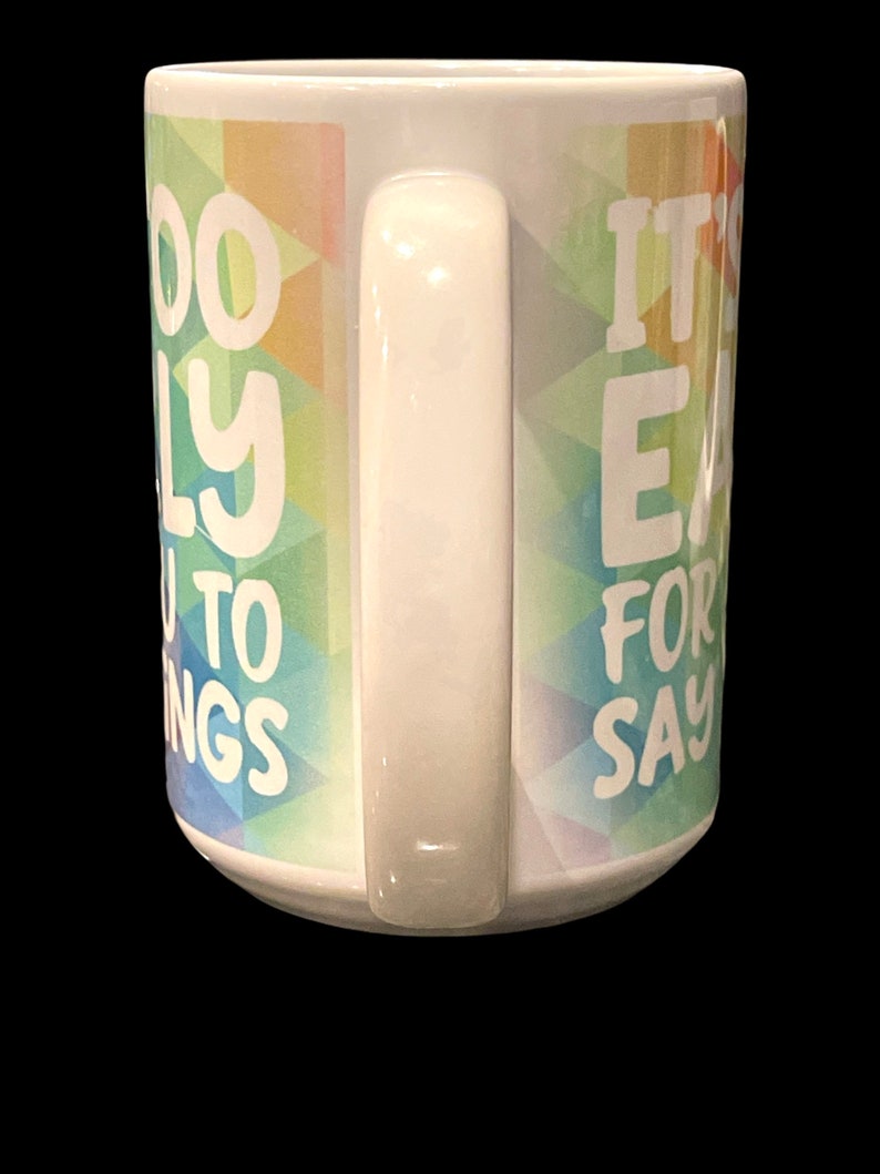 May include: White ceramic coffee mug with a colorful geometric pattern and the text "It's easy for you to say" on the right side and "Too busy to worry" on the left side.