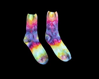 May include: A pair of colorful tie-dye socks with a rainbow pattern. The socks are made of a soft, comfortable material and are perfect for adding a pop of color to any outfit.