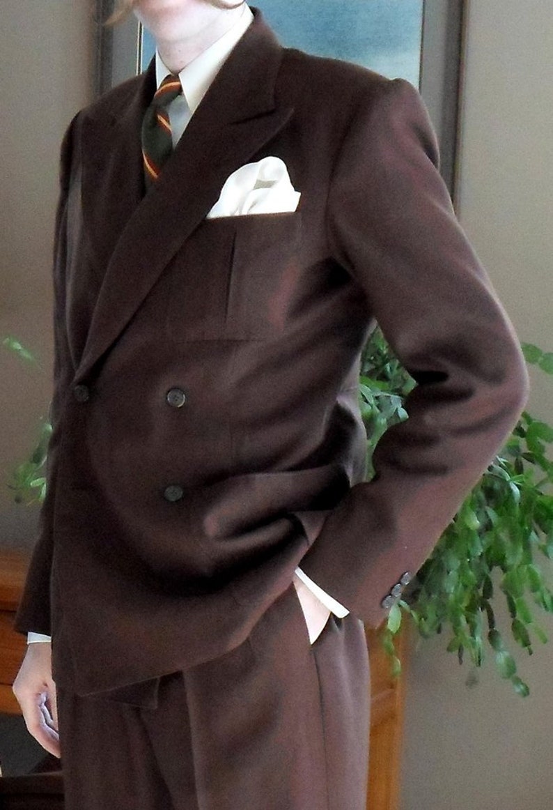 May include: A brown double-breasted suit jacket with a white pocket square and a striped tie.