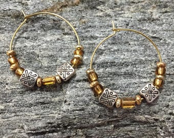 Beaded gold metal hoop earrings with celtic metal bead accents