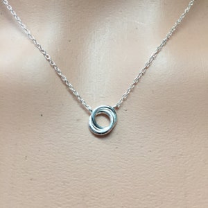 May include: A silver chain necklace with a small, interlocking circle pendant.