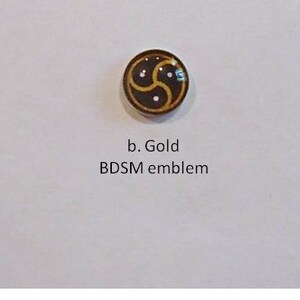 May include: Three BDSM emblems in black and white, gold, and silver. Each emblem features a stylized triskelion design. The text below each emblem reads "Black and white BDSM emblem", "Gold BDSM emblem", and "Silver BDSM emblem".