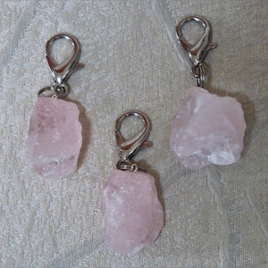 May include: Three pink rose quartz crystal keychains with silver metal clasps.