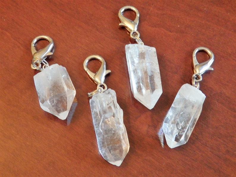 May include: Four clear quartz crystal point keychains with silver metal clasps. The crystals are all different shapes and sizes.