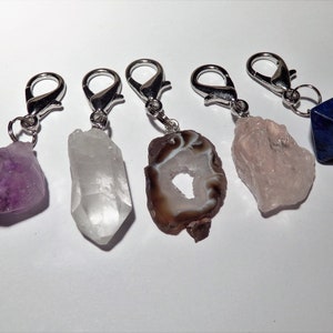 May include: Five crystal keychains with silver clasps. The crystals are amethyst, clear quartz, agate, rose quartz, and lapis lazuli.