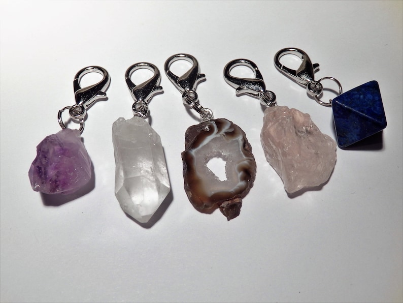 May include: Five crystal keychains with silver clasps. The crystals are amethyst, clear quartz, agate, rose quartz, and lapis lazuli.