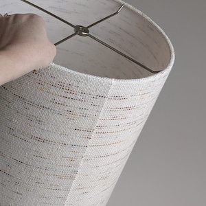 hand holding a Confetti handwoven fabric lamp shade with nickel hardware