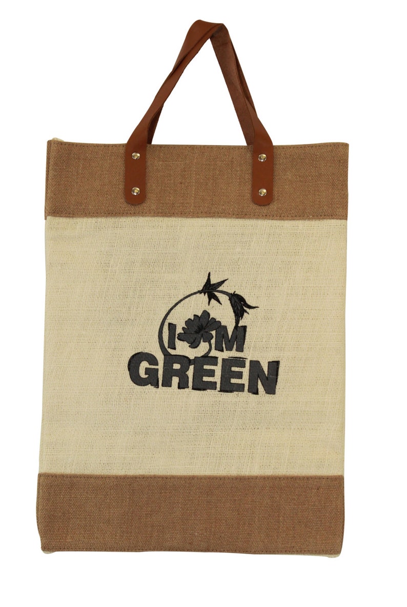 Puede incluir: Una bolsa de mano marr&oacute;n y beige con asas de cuero. La bolsa tiene un dise&ntilde;o bordado que dice "I'm Green" con una peque&ntilde;a flor.