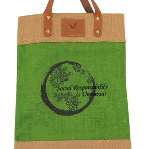 Puede incluir: Una bolsa de tela verde y marr&oacute;n con asas de cuero. La bolsa tiene un dise&ntilde;o circular con el texto "Social Responsibility is Universal".