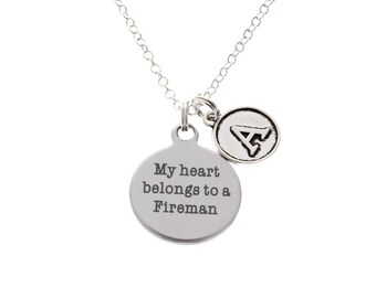 May include: Silver necklace with a round pendant that says "My heart belongs to a Fireman" and a smaller pendant with a triangle symbol.