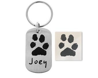 May include: Silver dog tag keychain with a black paw print and the name "Joey" engraved on it. The tag is attached to a silver key ring.