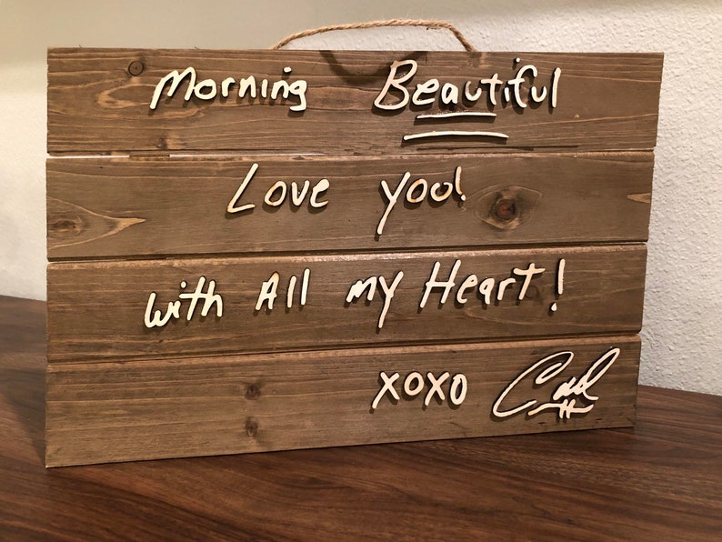 May include: Wooden sign with the words "Morning Beautiful", "Love you!" and "with all my heart!" written in white paint. The sign is signed "xoxo Carl".