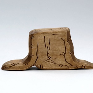 Peut inclure: Une souche d'arbre en bois avec un motif sculpt&eacute;, la souche est brun clair et a une finition en bois naturel.