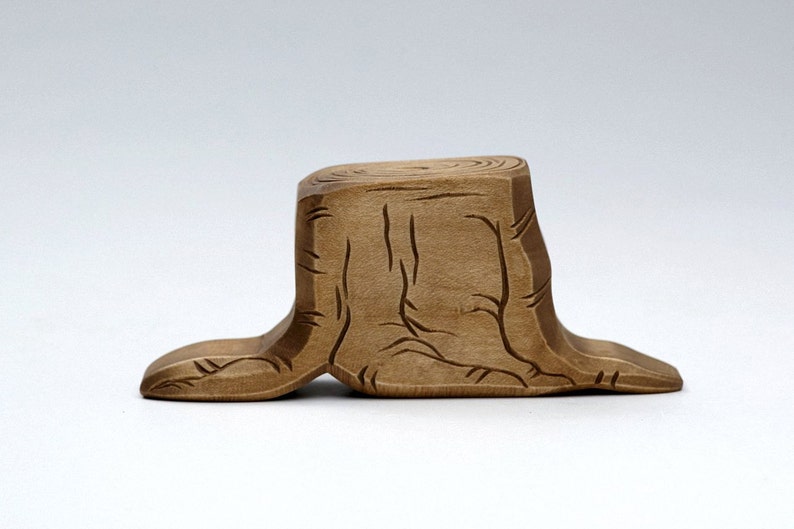 Peut inclure: Une souche d'arbre en bois avec un motif sculpt&eacute;, la souche est brun clair et a une finition en bois naturel.