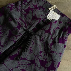 May include: Purple and gray floral skirt with a black drawstring tie. The skirt has a label that reads "GAR&Ccedil;ON" and "S".