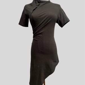 May include: A dark gray asymmetrical dress with a mandarin collar and short sleeves. The dress is made of a soft, stretchy fabric and has a relaxed fit.