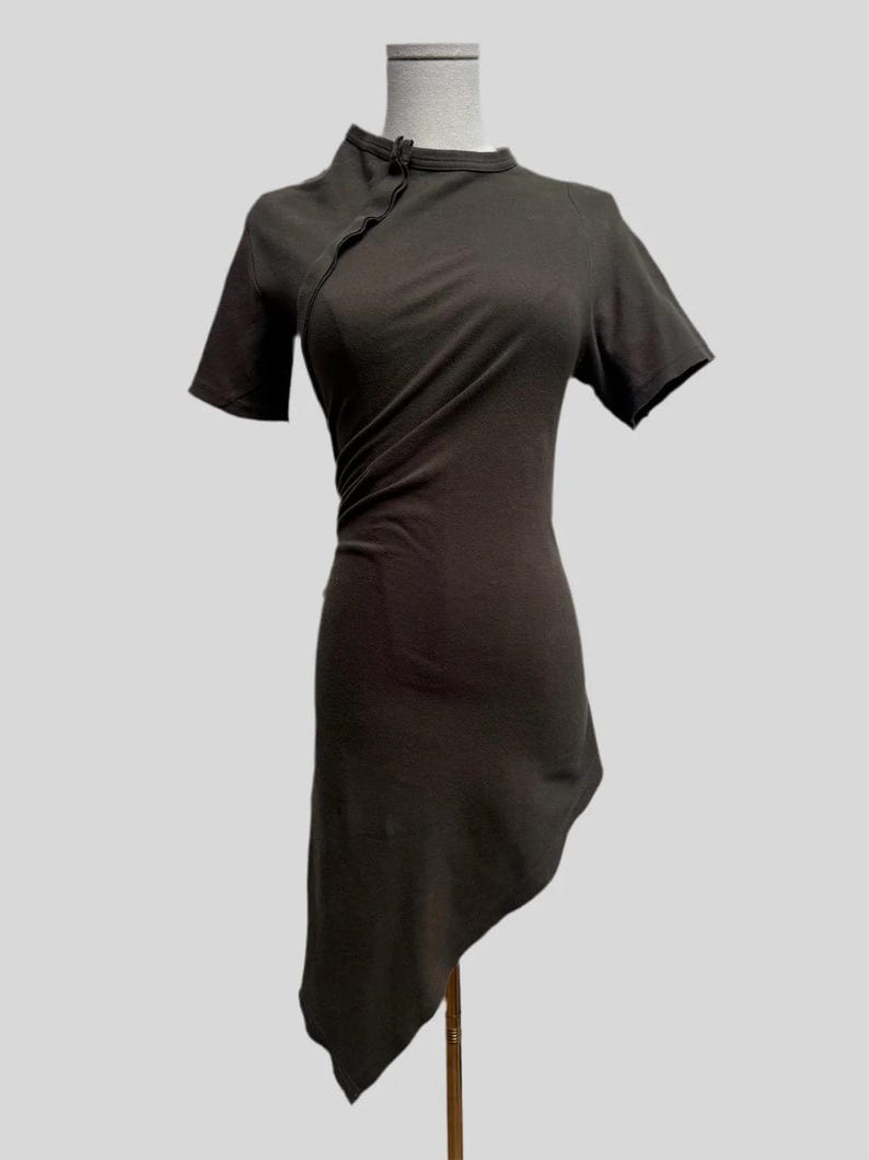 May include: A dark gray asymmetrical dress with a mandarin collar and short sleeves. The dress is made of a soft, stretchy fabric and has a relaxed fit.