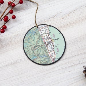 May include: A round, green and white map ornament with a black border. The map shows the area around Sheboygan, Wisconsin. The ornament has a string for hanging.