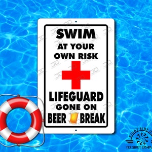 Puede incluir: Un letrero rectangular blanco con texto negro que dice "SWIM AT YOUR OWN RISK" encima de una cruz roja y las palabras "LIFEGUARD GONE ON BEER BREAK". Un salvavidas rojo y blanco está en la esquina inferior izquierda.