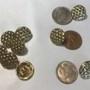 May include: A group of eight gold-colored buttons with a textured surface. The buttons are round and have a diameter of approximately 1 inch.