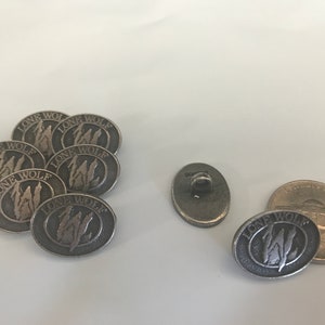 May include: A set of seven silver oval-shaped buttons with the words "Lone Wolf" and a wolf silhouette design. There is also a single silver button with a loop on the back.