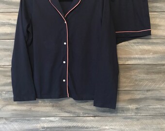 May include: A navy blue pajama set with a long-sleeved top and shorts. The top has a button-up front and a pink trim. The shorts have a drawstring waist and a pink trim.