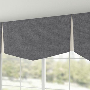 May include: A gray valance with a scalloped edge and a white lining. The valance is made of a textured fabric and is hung over a window.