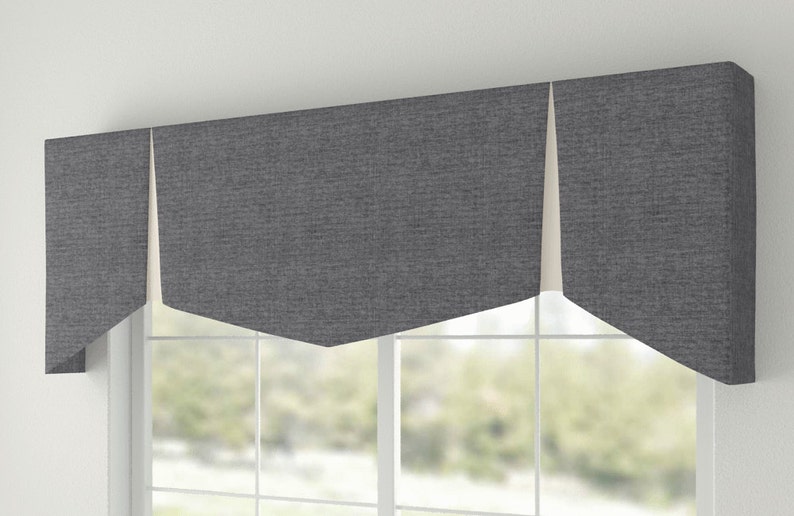 May include: A gray valance with a scalloped edge and a white lining. The valance is made of a textured fabric and is hung over a window.