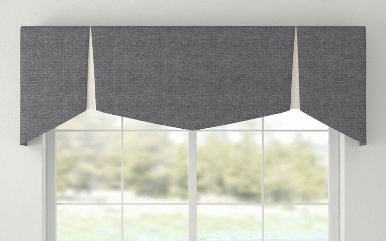 May include: A gray valance with a white lining, featuring a scalloped edge. The valance is hung above a window with a view of trees and a grassy area.