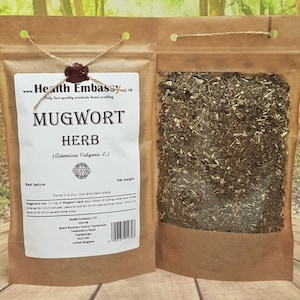 May include: A brown paper bag with a clear window, containing dried mugwort herb. The bag has a label that reads "Mugwort Herb (Artemisia Vulgaris L.)" and includes instructions for use and storage. The label also includes the company name "Health Embassy LTD" and contact information.
