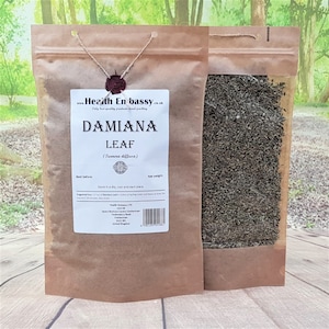 Puede incluir: Una bolsa de papel marrón con una ventana transparente que muestra hojas de Damiana secas en su interior. La bolsa tiene una etiqueta que dice "Damiana Leaf (Turnera diffusa)" e incluye información sobre el producto y la empresa, Health Embassy LTD.