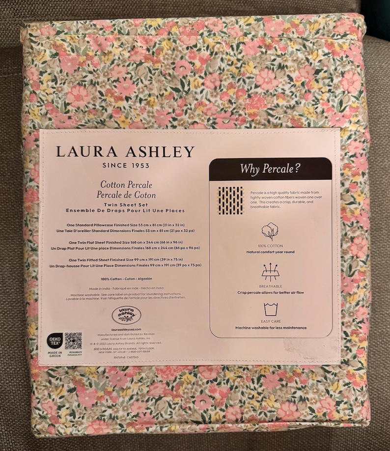 May include: A Twin Sheet Set by Laura Ashley, featuring a floral pattern in pink, yellow, and green. The packaging includes details about the cotton percale fabric, with dimensions for pillowcases and sheets, including a flat sheet measuring 66 x 96 inches.
