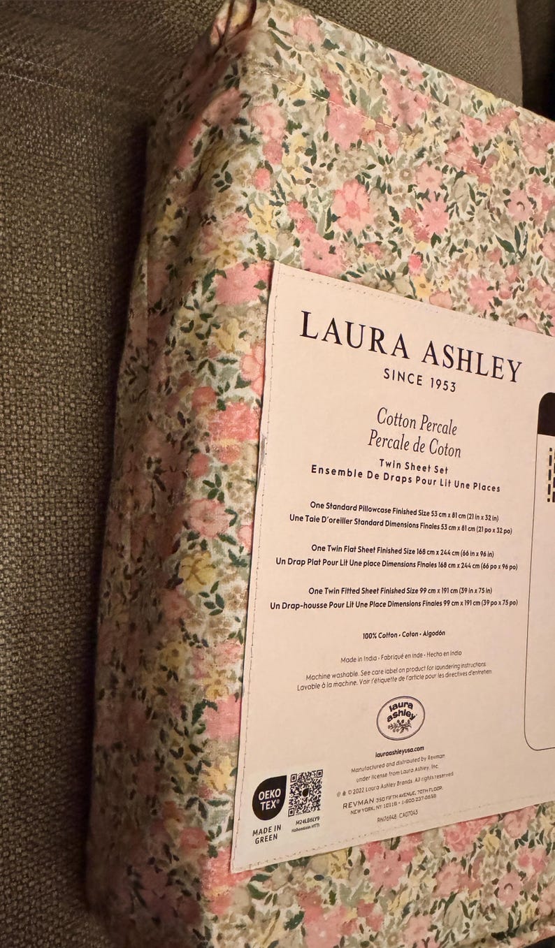May include: Twin sheet set by Laura Ashley, featuring a floral pattern in pink, yellow, and green. The set includes a flat sheet (66 in x 96 in), a fitted sheet (39 in x 75 in), and a pillowcase (21 in x 32 in). Made of 100% cotton.
