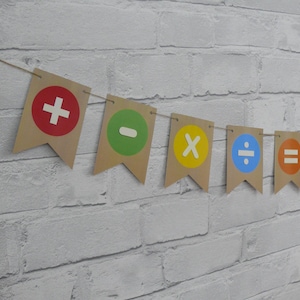 May include: A brown paper banner with colourful circles featuring maths symbols: plus, minus, multiply, divide, equals, and a number sign.