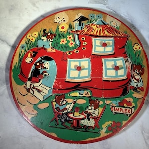 May include: Vintage wooden puzzle featuring a red boot-shaped house with bears. The puzzle has a circular shape with a green lawn, flowers, and bears engaged in various activities. The word "SIMPLEX" is visible.
