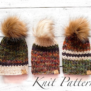Puede incluir: Tres gorros de punto con pompones de piel sintética en diferentes combinaciones de colores. Los gorros son de rayas con tonos de verde, marrón, naranja y crema. Los pompones son marrones, crema y marrones. Los gorros están dispuestos en fila sobre una superficie de madera blanca. Patrón de punto.