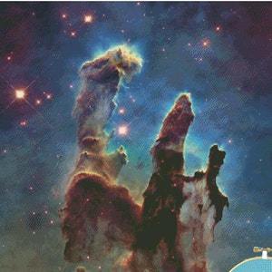 Puede incluir: Patrón de punto de cruz que presenta una nebulosa colorida con estructuras imponentes y estrellas brillantes. El diseño incluye un círculo azul con el texto "sew FLOSSY FLOSSY". La paleta de colores incluye tonos de azul, marrón y dorado.