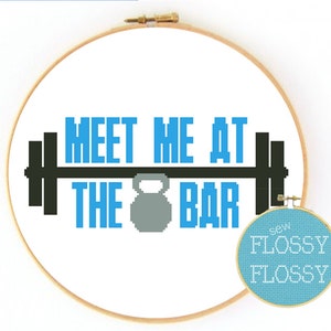 May include: Cross stitch pattern featuring a barbell with the text "Meet me at the bar" in blue and black. The pattern is on a white background and is framed in a wooden hoop. The text "Sew Flossy Flossy" is in blue on a light blue background.