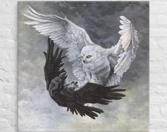 May include: A white snowy owl with yellow eyes and a black crow are facing each other in a dramatic pose against a cloudy gray background.