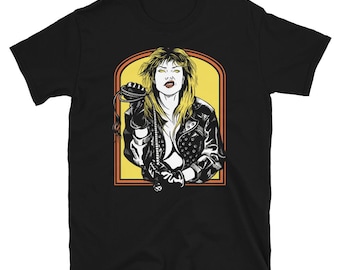 May include: Black t-shirt with a graphic of a woman in a leather jacket and a whip. The woman has blonde hair and is wearing a black leather jacket with studs. The background is yellow and orange.