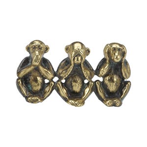 May include: Three gold-coloured monkey figurines, each with a different gesture: one covering its mouth, one covering its eyes, and one covering its ears. The monkeys are sitting side-by-side.