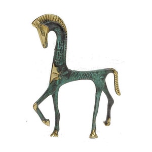 May include: A stylised horse figurine crafted from metal, featuring a combination of polished gold-tone brass and a weathered, oxidised green patina finish. The design includes geometric patterns along the neck and body with a raised tail.