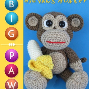 May include: A crocheted monkey toy holding a yellow banana. The monkey is brown with black eyes and a red mouth. The toy is sitting on a blue background. The text "BIG PAWS MONKEY" is at the top of the image. The text "Hey Can You Crochet Me A" is at the bottom of the image.
