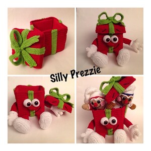 Puede incluir: Una caja de regalo roja de crochet con una cinta verde y ojos blancos. La caja est&aacute; abierta y tiene una caja de regalo de crochet m&aacute;s peque&ntilde;a dentro. El texto "Silly Prezzie" est&aacute; escrito en la imagen.